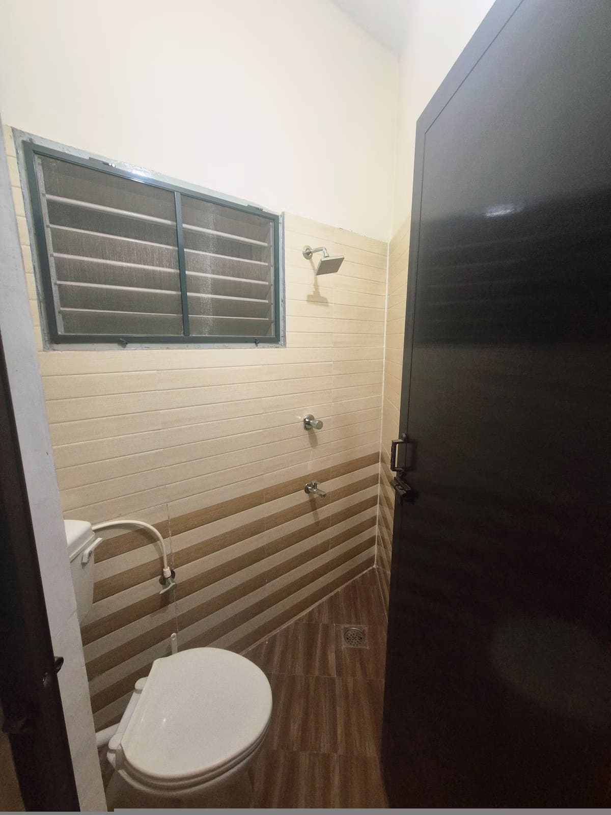 The third bathroom, finished in ribbed white tile with a louvred window