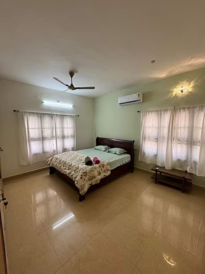 Bedroom 1 on the ground floor, with a king-size bed, air conditioning and curtained windows on two walls