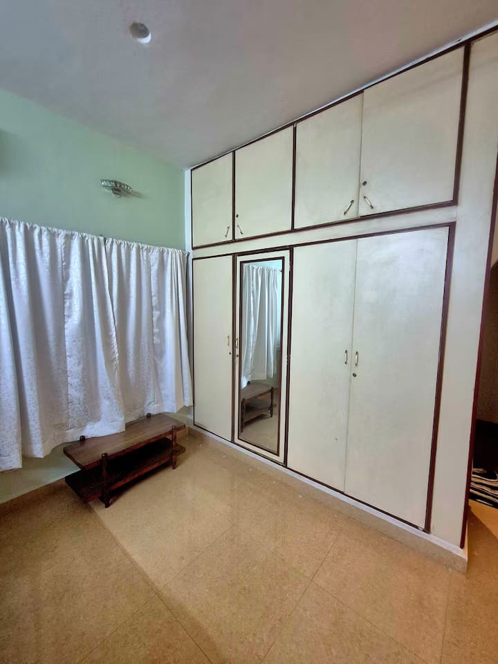 The full-height mirrored wardrobe running along one wall of bedroom 1