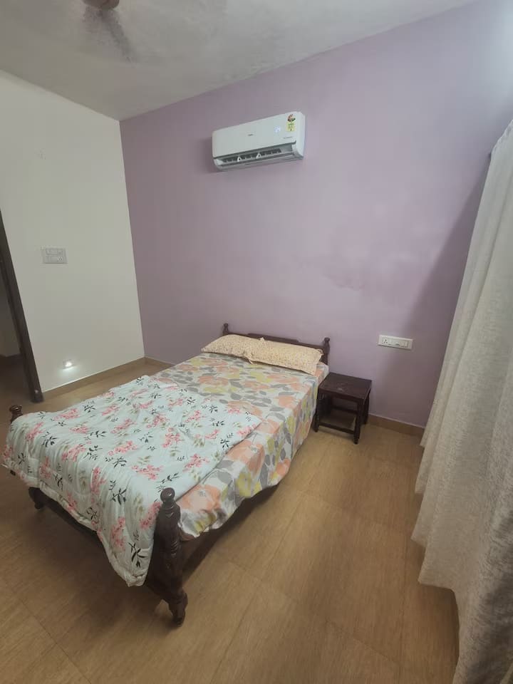 Bedroom 3 with a double bed, lilac walls, air conditioning and a bedside table