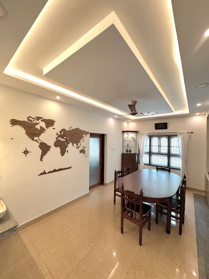 The dining room looking towards the entrance, with cove lighting and the world map wall feature