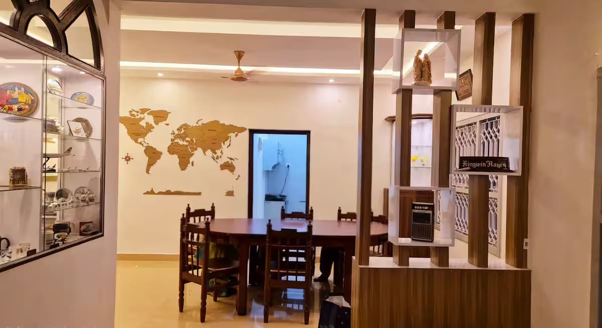 The carved wooden partition separating the dining area from the living room, beside the display cabinets