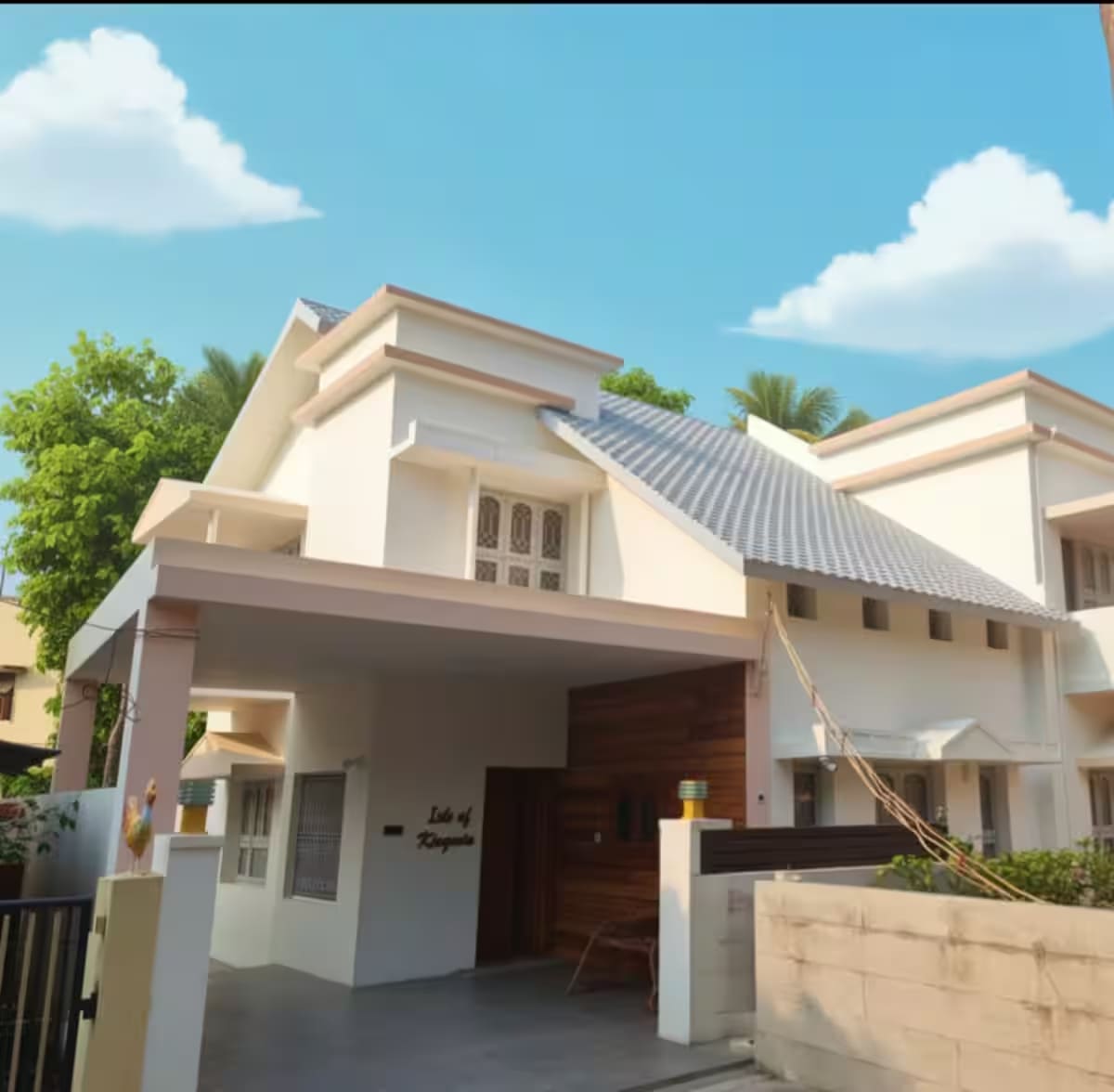The front of Kingwin Villa, a white two-storey house with a sloped grey roof and covered car parking