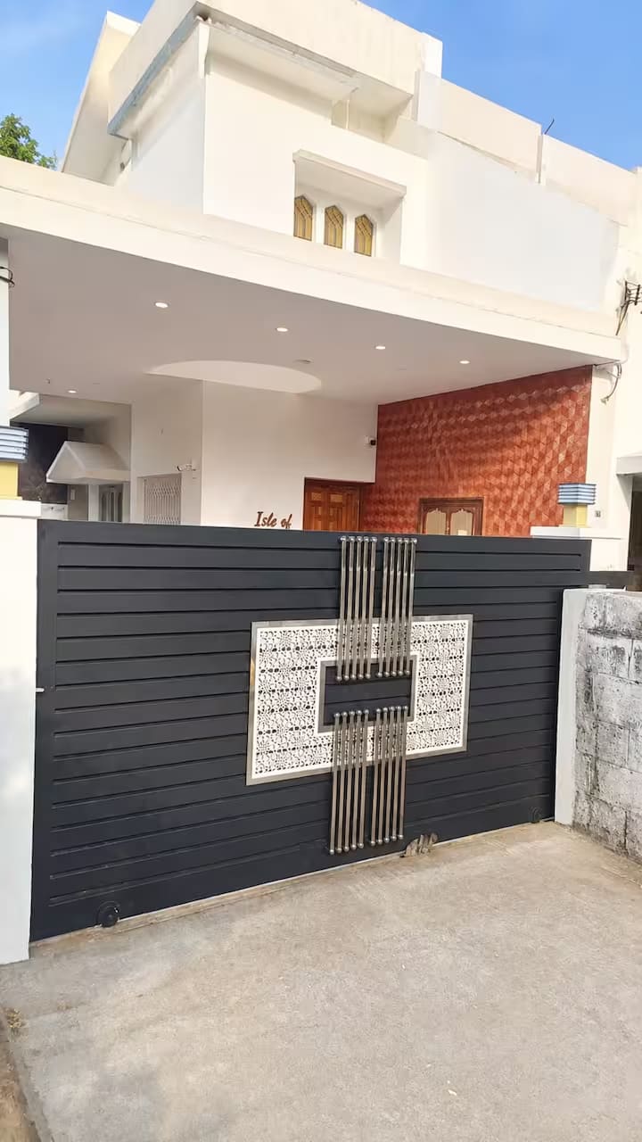 The front gate and boundary wall, with a brick-textured feature panel beside the entrance