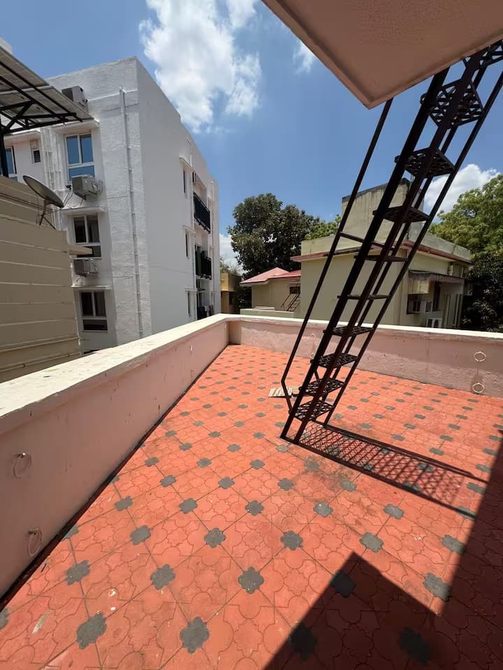 The open roof terrace laid with red tiles, with its access ladder and views over the neighbourhood