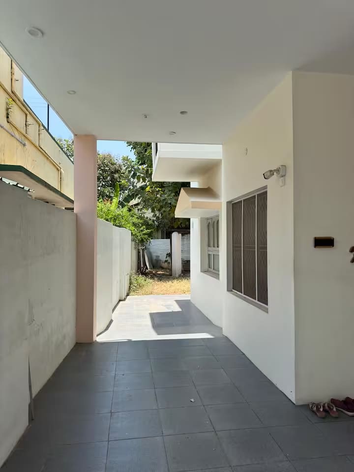 The tiled walkway running down the side of the house past the garden wall