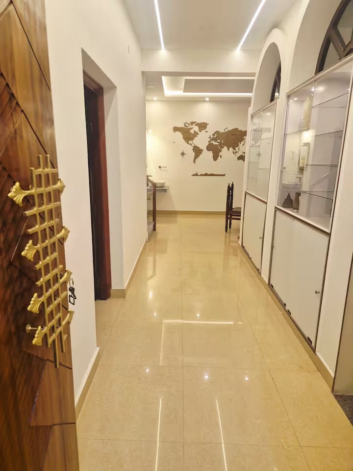 The polished hallway lined with glass display cabinets, leading through to the dining area