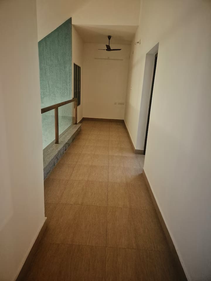The upstairs corridor with a green feature wall, connecting the two upper bedrooms